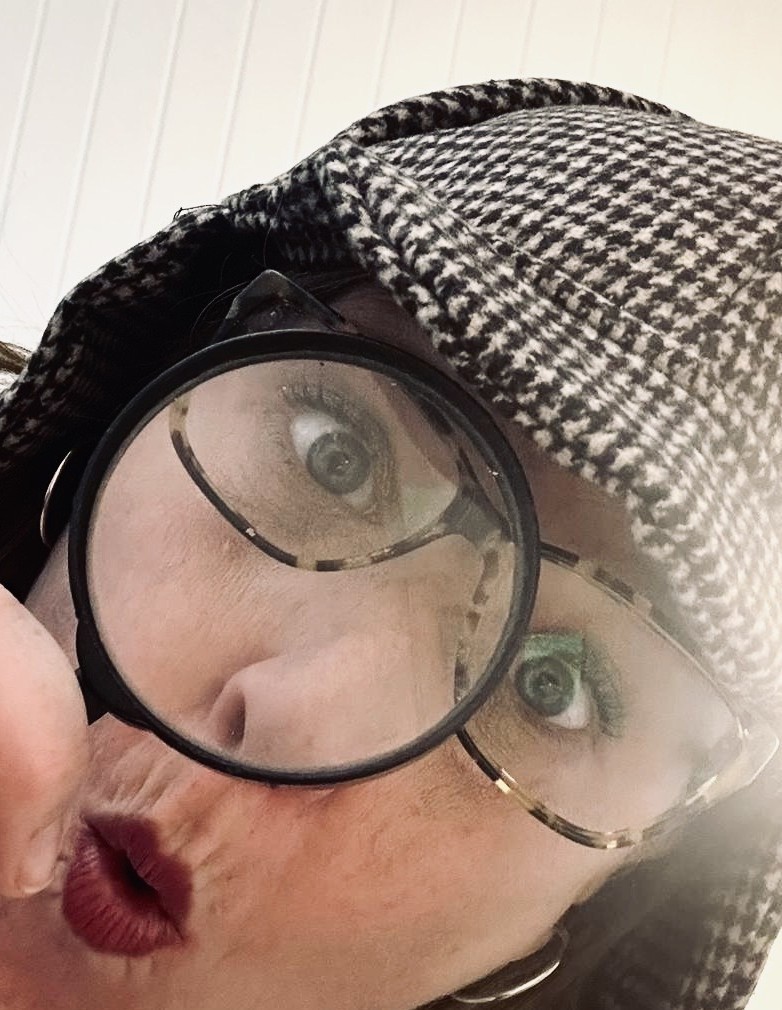 Sarah in a deerstalker hat, magnifying glass to her eye.